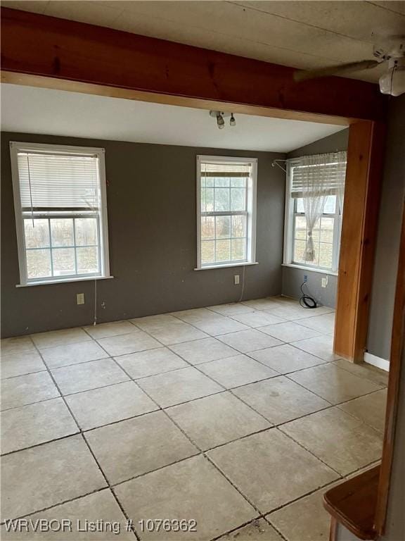 tiled spare room featuring ceiling fan