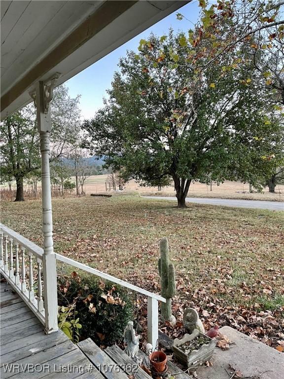 view of yard with covered porch and a rural view