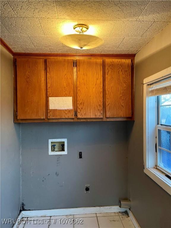 laundry area featuring cabinets, hookup for a washing machine, light tile patterned floors, and hookup for an electric dryer