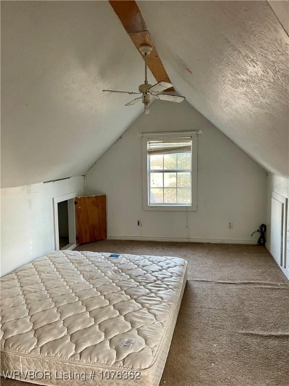 bonus room featuring ceiling fan, light colored carpet, a textured ceiling, and vaulted ceiling