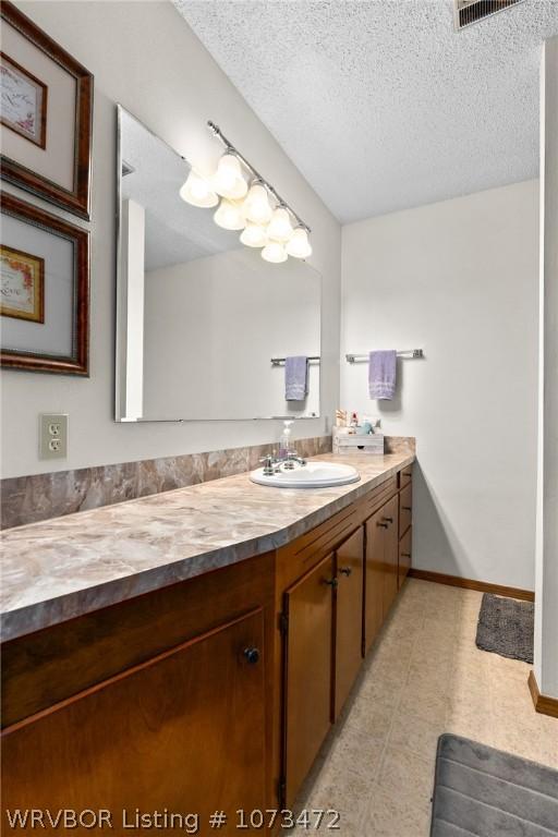 bathroom with vanity and a textured ceiling