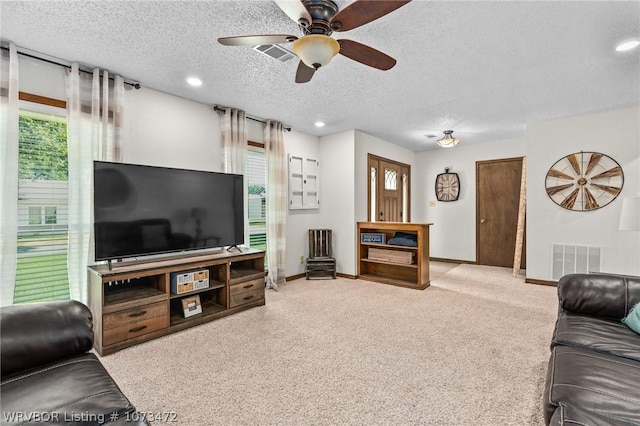 living room with plenty of natural light, ceiling fan, and a textured ceiling