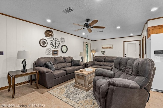 tiled living room with ceiling fan, crown molding, wood walls, and a textured ceiling