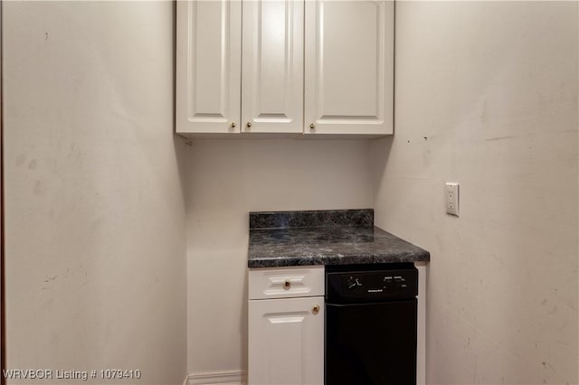 kitchen featuring dark countertops and white cabinetry