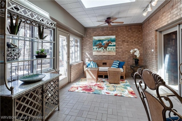 sunroom with rail lighting and a ceiling fan