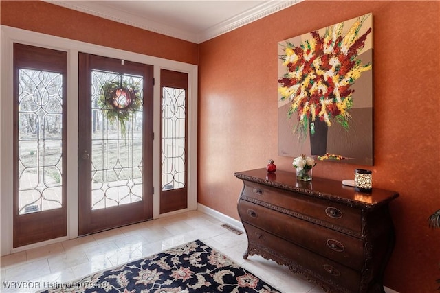 entryway featuring light tile patterned floors, visible vents, baseboards, and ornamental molding