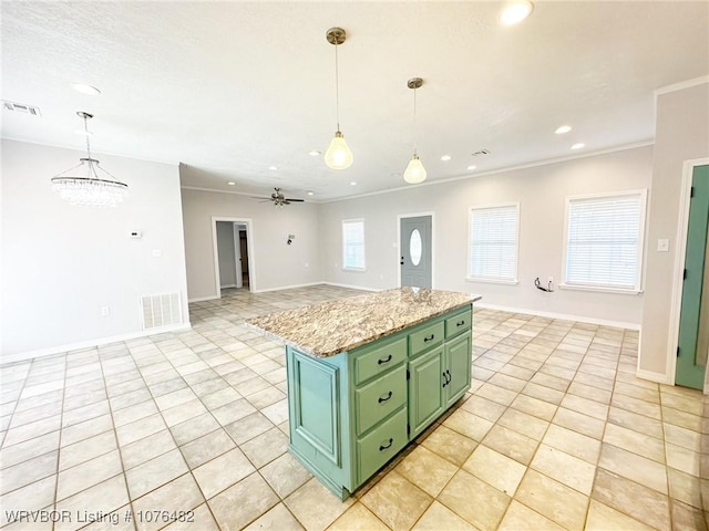 kitchen featuring ceiling fan, light tile patterned floors, green cabinetry, a center island, and hanging light fixtures