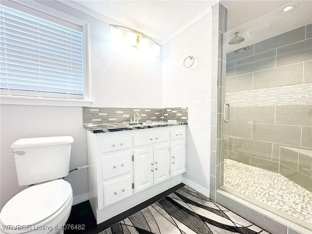 bathroom featuring vanity, decorative backsplash, toilet, a textured ceiling, and a shower with shower door