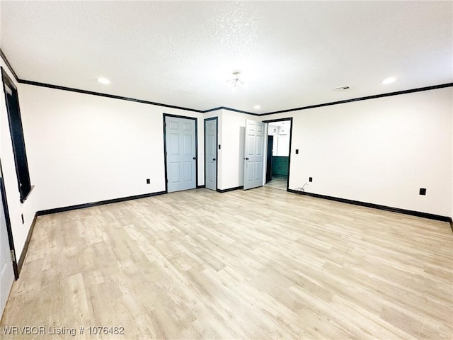 interior space featuring a textured ceiling, light hardwood / wood-style floors, and crown molding