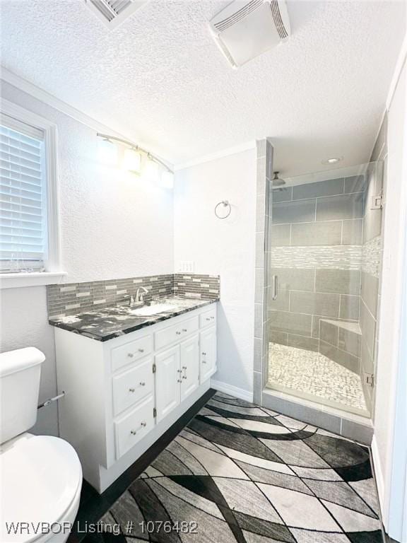 bathroom featuring backsplash, a textured ceiling, toilet, vanity, and a shower with shower door