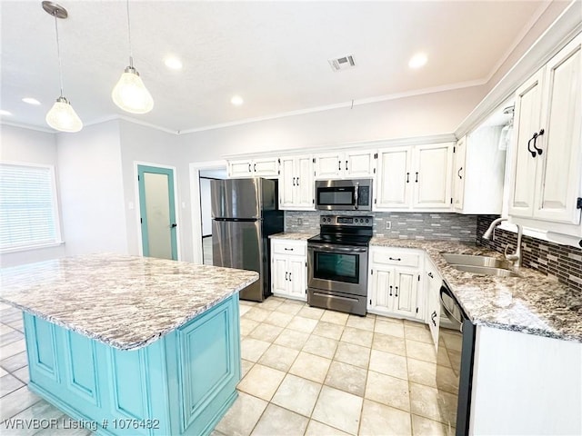 kitchen featuring pendant lighting, white cabinets, sink, appliances with stainless steel finishes, and a kitchen island