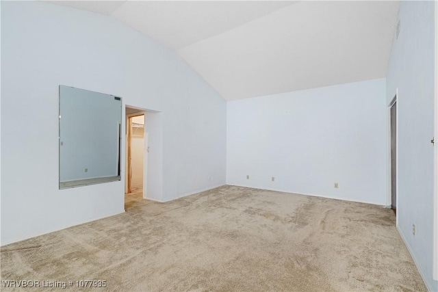 spare room with carpet floors and vaulted ceiling