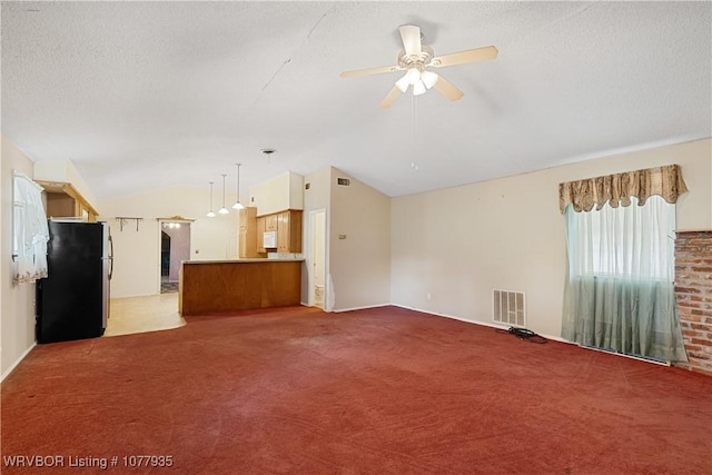 unfurnished living room featuring light colored carpet, vaulted ceiling, and ceiling fan