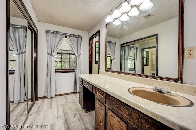 bathroom with vanity, a textured ceiling, and hardwood / wood-style flooring