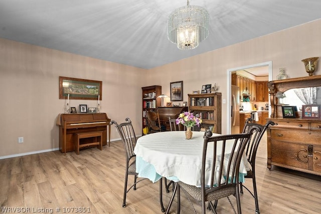 dining room with a notable chandelier and light wood-type flooring