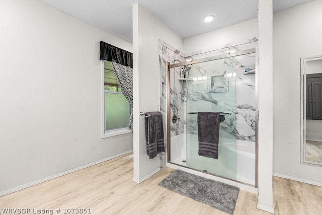 bathroom with hardwood / wood-style floors and a shower with shower door