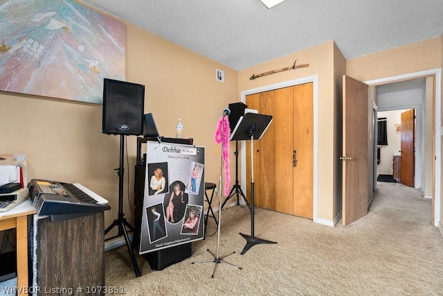 workout room featuring carpet flooring and a textured ceiling