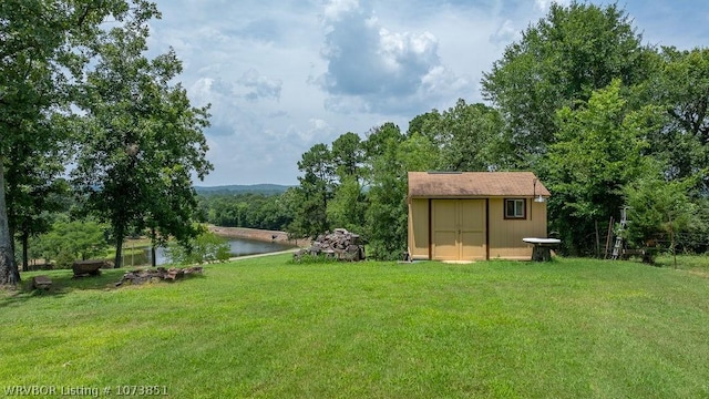 view of yard with a water view and a shed