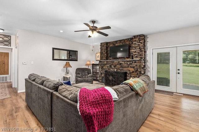 2055 Barber Rd, Booneville, AR 72927 - living room with wood finished floors, a ceiling fan, a fireplace, and french doors