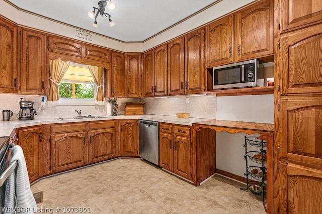 kitchen featuring appliances with stainless steel finishes, backsplash, an inviting chandelier, and sink