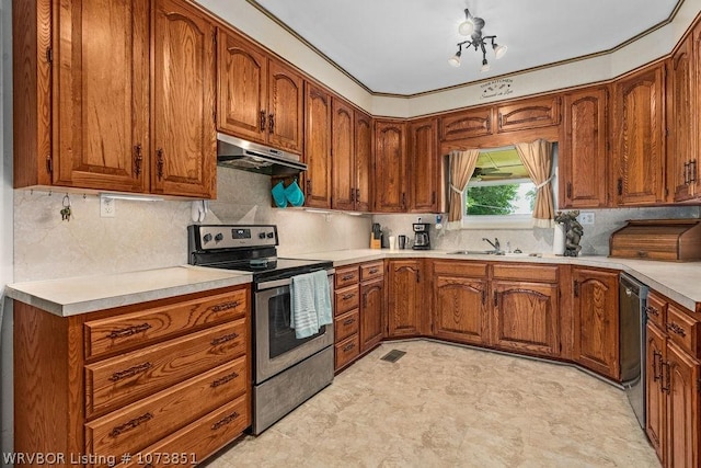2055 Barber Rd, Booneville, AR 72927 - kitchen featuring stainless steel appliances, under cabinet range hood, brown cabinets, light countertops, and backsplash