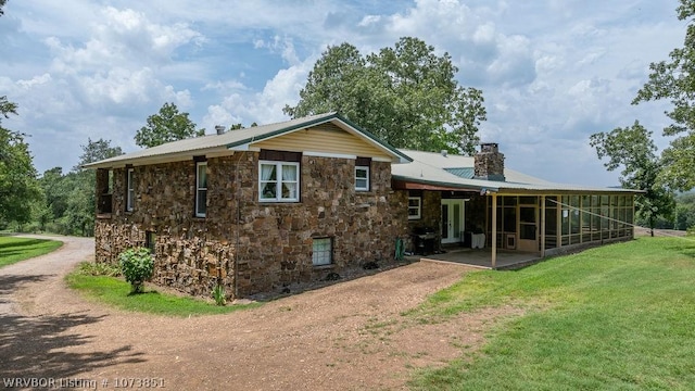 back of property featuring a sunroom and a yard