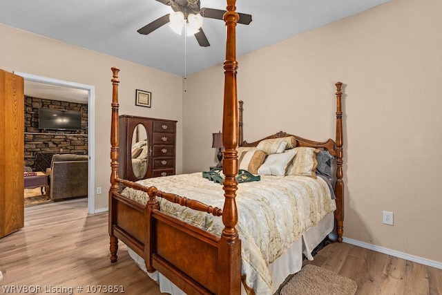 bedroom featuring a walk in closet, a closet, light hardwood / wood-style flooring, and ceiling fan