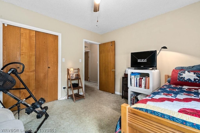 bedroom with ceiling fan, a closet, carpet floors, and a textured ceiling