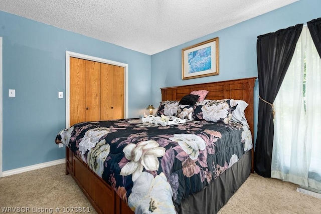 carpeted bedroom featuring a textured ceiling and a closet