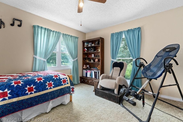 carpeted bedroom with ceiling fan and a textured ceiling