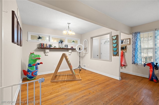 interior space featuring hardwood / wood-style flooring, an inviting chandelier, and a textured ceiling
