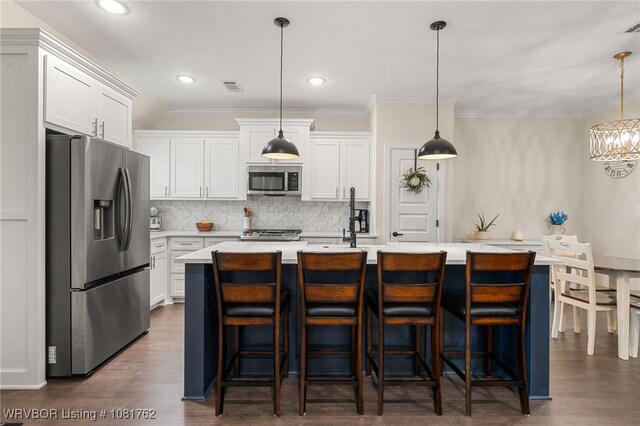8323 Mclaren Dr, Fort Smith, AR 72916 - kitchen featuring appliances with stainless steel finishes, light countertops, backsplash, a center island with sink, and ornamental molding