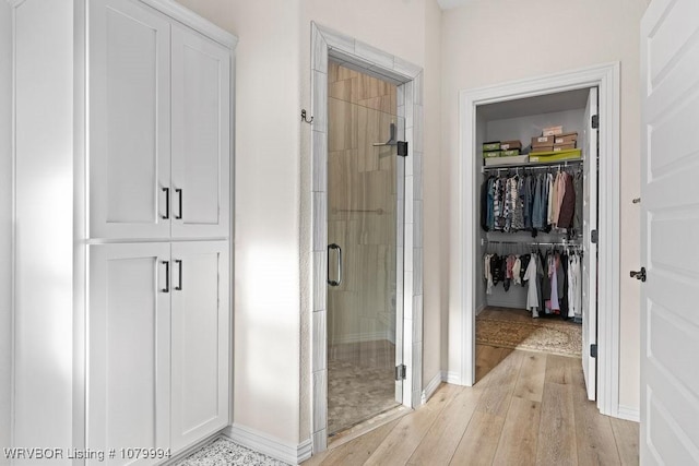 7907 Coltridge Way, Fort Smith, AR 72916 - bathroom with baseboards, wood finished floors, a walk in closet, and a shower stall