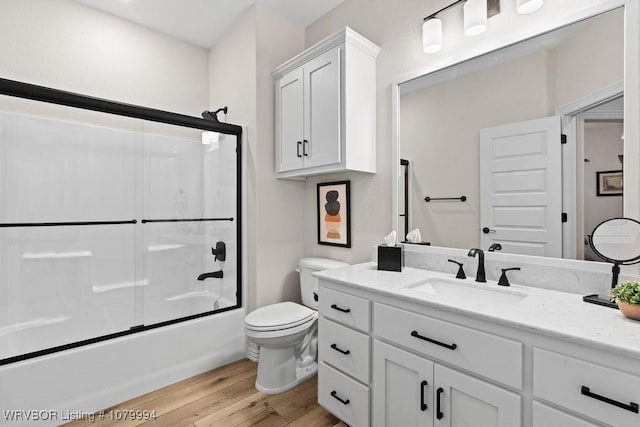 7907 Coltridge Way, Fort Smith, AR 72916 - bathroom featuring toilet, vanity, enclosed tub / shower combo, and wood finished floors
