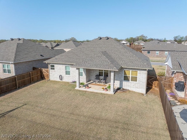 7907 Coltridge Way, Fort Smith, AR 72916 - back of property with a patio, a fenced backyard, brick siding, a shingled roof, and a yard