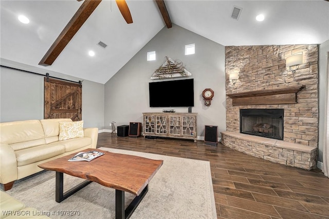 living room with high vaulted ceiling, a stone fireplace, ceiling fan, a barn door, and beam ceiling