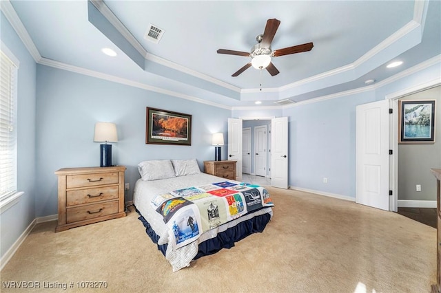 bedroom featuring ceiling fan, a raised ceiling, light colored carpet, and ornamental molding