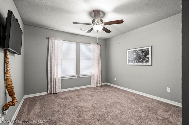 unfurnished room featuring ceiling fan, carpet floors, and a textured ceiling