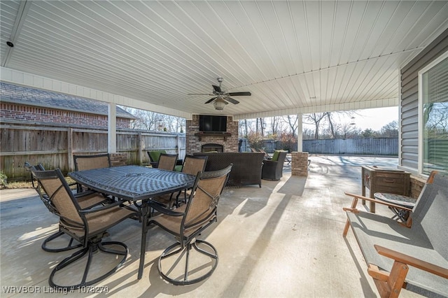 view of patio / terrace featuring ceiling fan and an outdoor brick fireplace