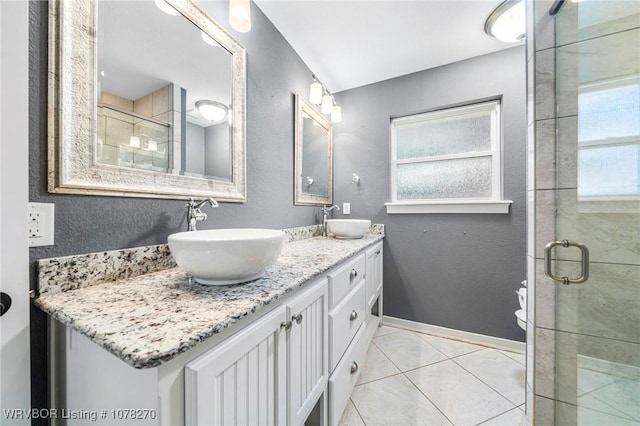 bathroom featuring tile patterned flooring, vanity, toilet, and walk in shower