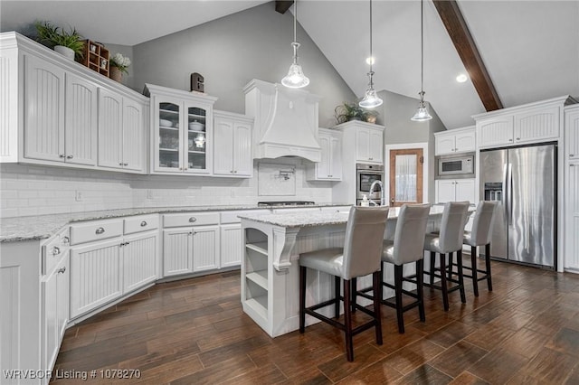 kitchen featuring white cabinets, appliances with stainless steel finishes, tasteful backsplash, and a kitchen island with sink