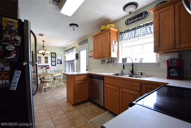 104527 S 4670th Rd, Sallisaw, OK 74955 - kitchen featuring appliances with stainless steel finishes, a peninsula, light countertops, light tile patterned floors, and a chandelier