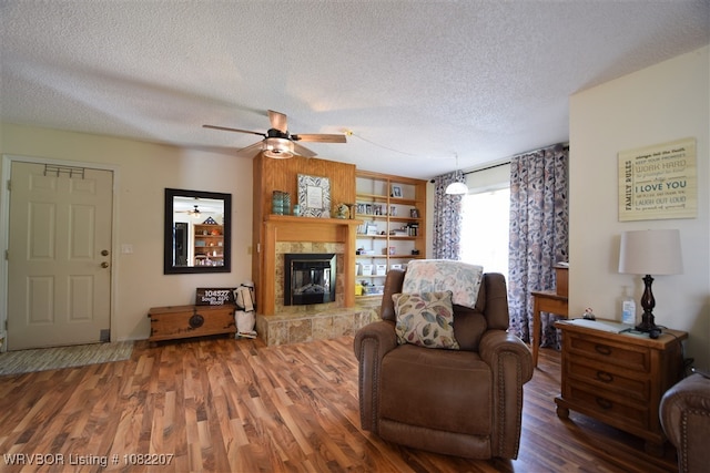 104527 S 4670th Rd, Sallisaw, OK 74955 - living area with a textured ceiling, a ceiling fan, wood finished floors, and a tile fireplace
