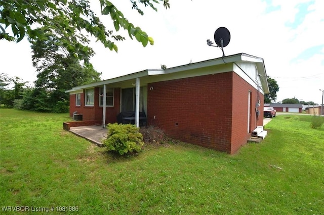 807 S 2nd St, Stilwell, OK 74960 - view of side of home with a lawn, brick siding, and a patio area