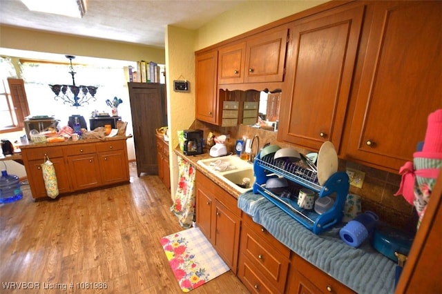 807 S 2nd St, Stilwell, OK 74960 - kitchen with brown cabinets, light wood-style floors, light countertops, and hanging light fixtures