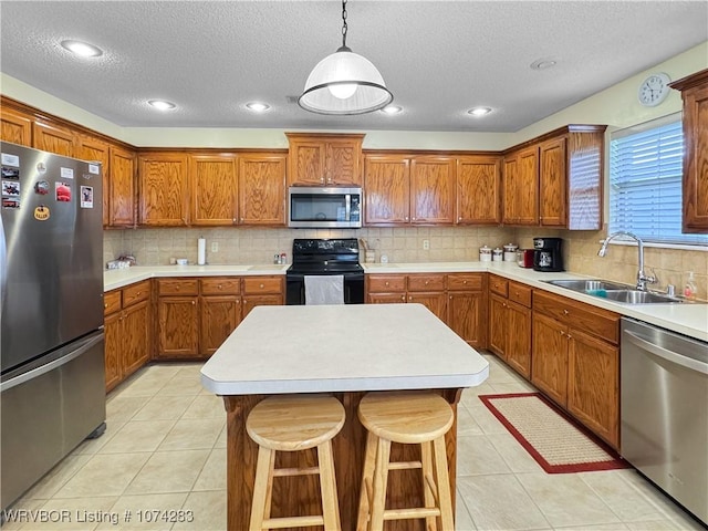 kitchen featuring appliances with stainless steel finishes, backsplash, a kitchen breakfast bar, sink, and pendant lighting