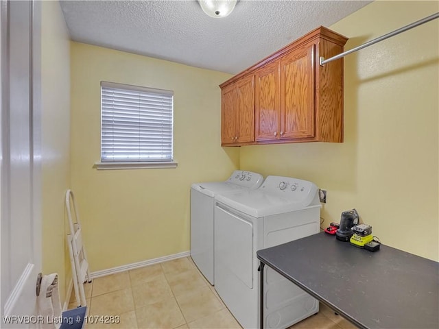 washroom with separate washer and dryer, light tile patterned floors, cabinets, and a textured ceiling