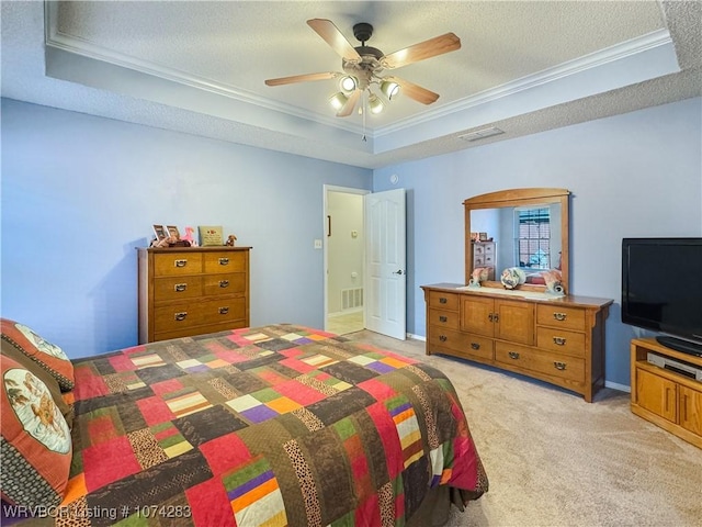 bedroom with ceiling fan, ornamental molding, light carpet, and a tray ceiling