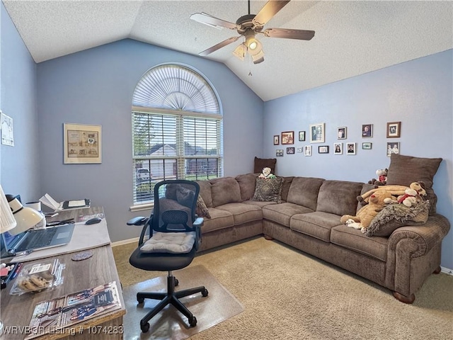 carpeted home office featuring a textured ceiling, ceiling fan, and vaulted ceiling