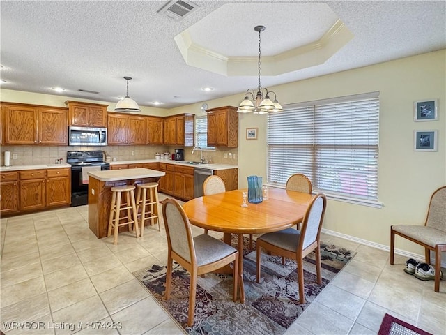 dining room featuring sink, a chandelier, a textured ceiling, a tray ceiling, and light tile patterned floors